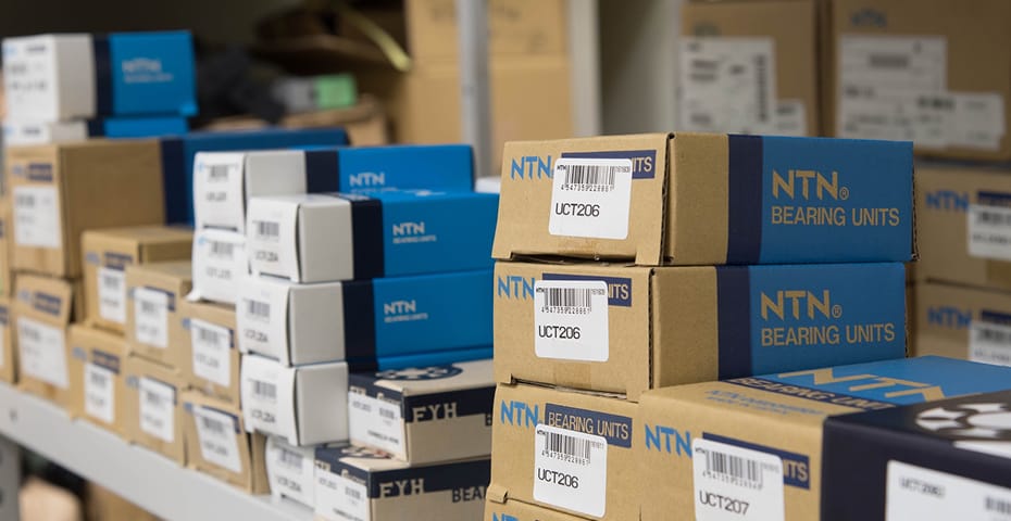 棚に積み上げられたNTN製ベアリングユニットの青と茶色の個別包装箱