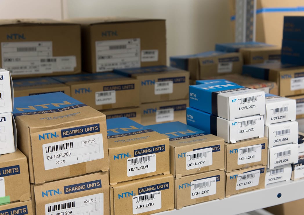 棚に整然と積み上げられた、NTN株式会社製のベアリングユニットの製品パッケージ群